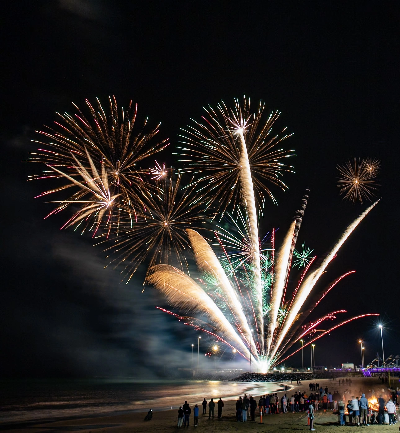 Large-scale fireworks show lighting up night sky at public event