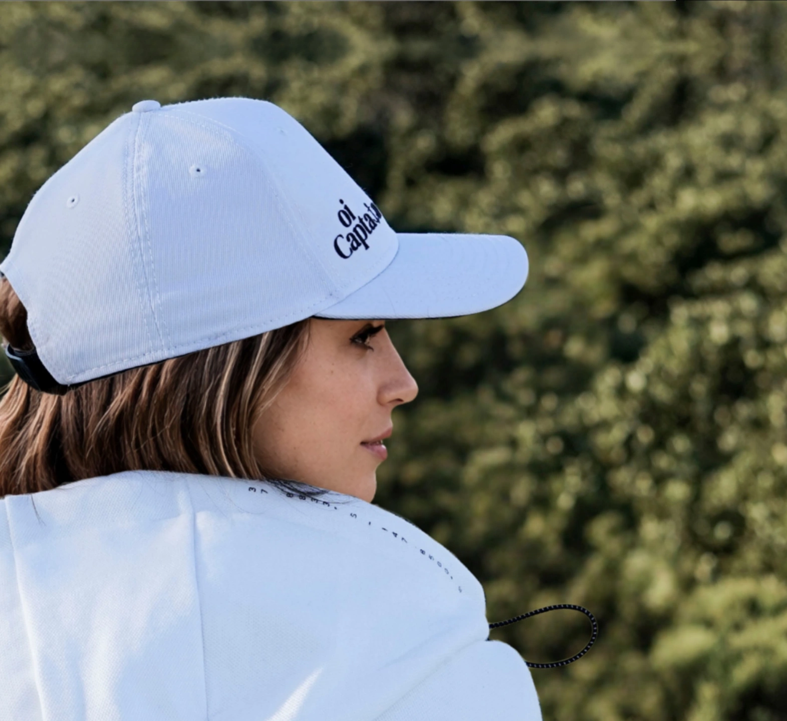 oi captain female model wearing endless cap white side view close up outdoors .jpg