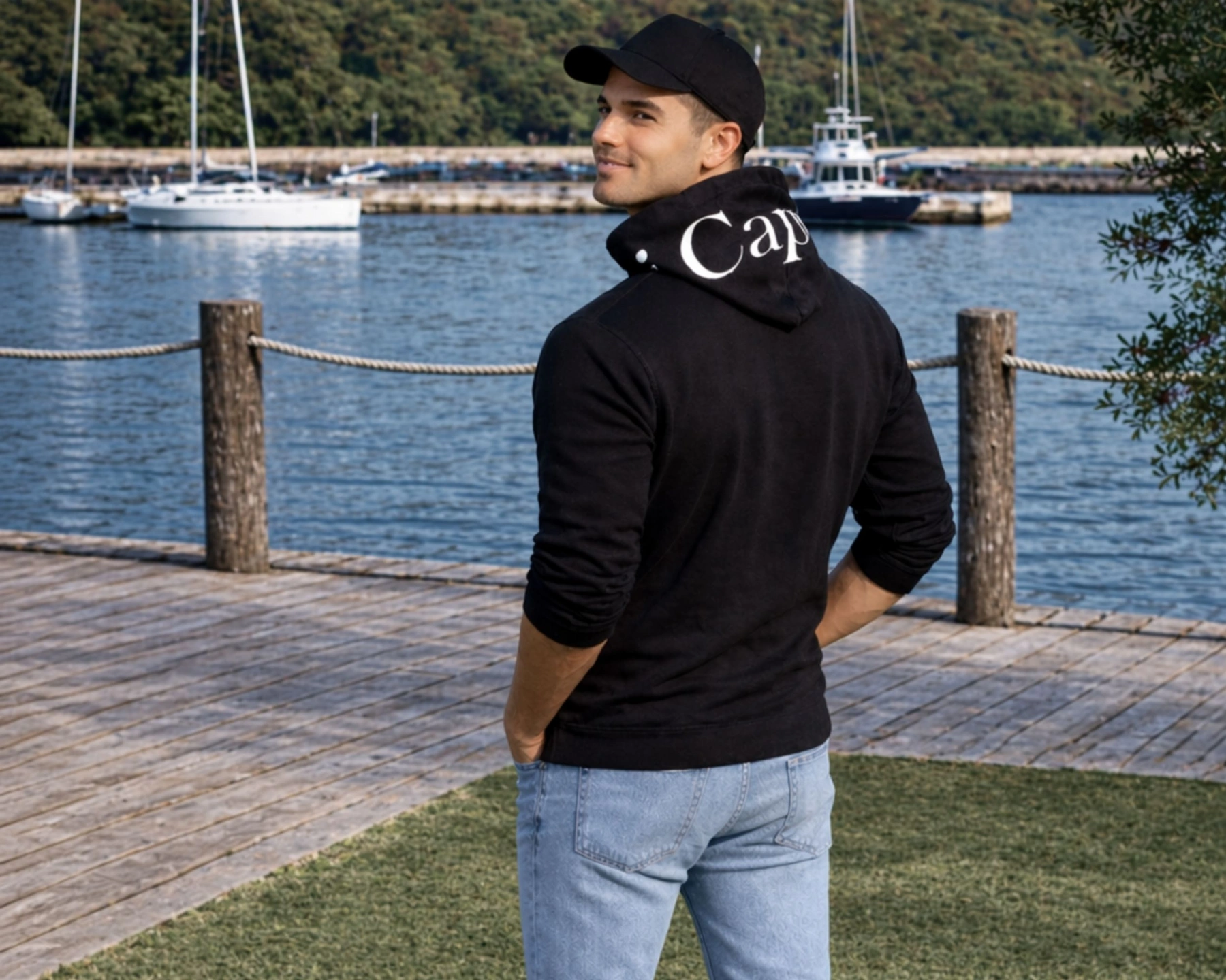 male model wearing oi captain baron hoodie full zip black back pose coastal lifestyle.jpg
