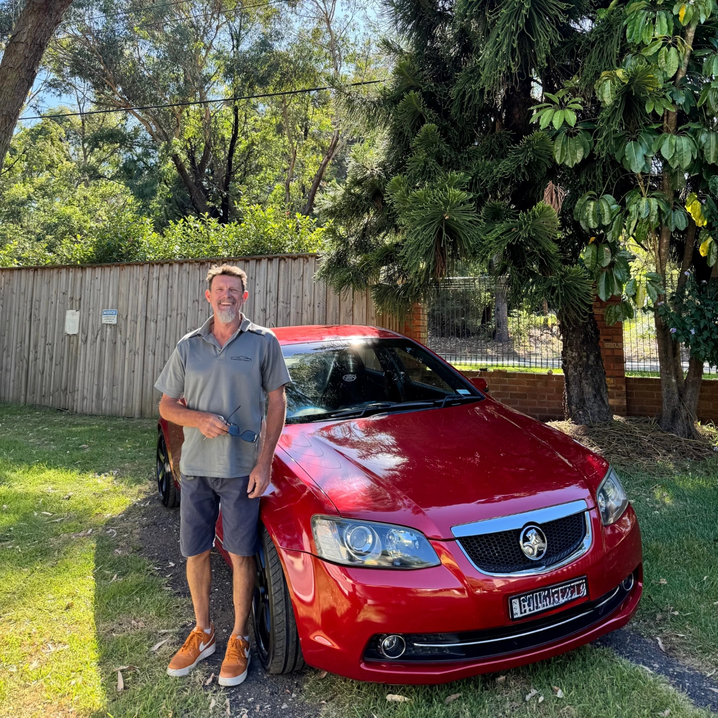 Paint By Popz detailer standing beside a freshly detailed red car, Sydney Northern Beaches