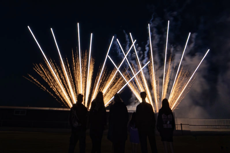Crowd watching fireworks display at outdoor community event
