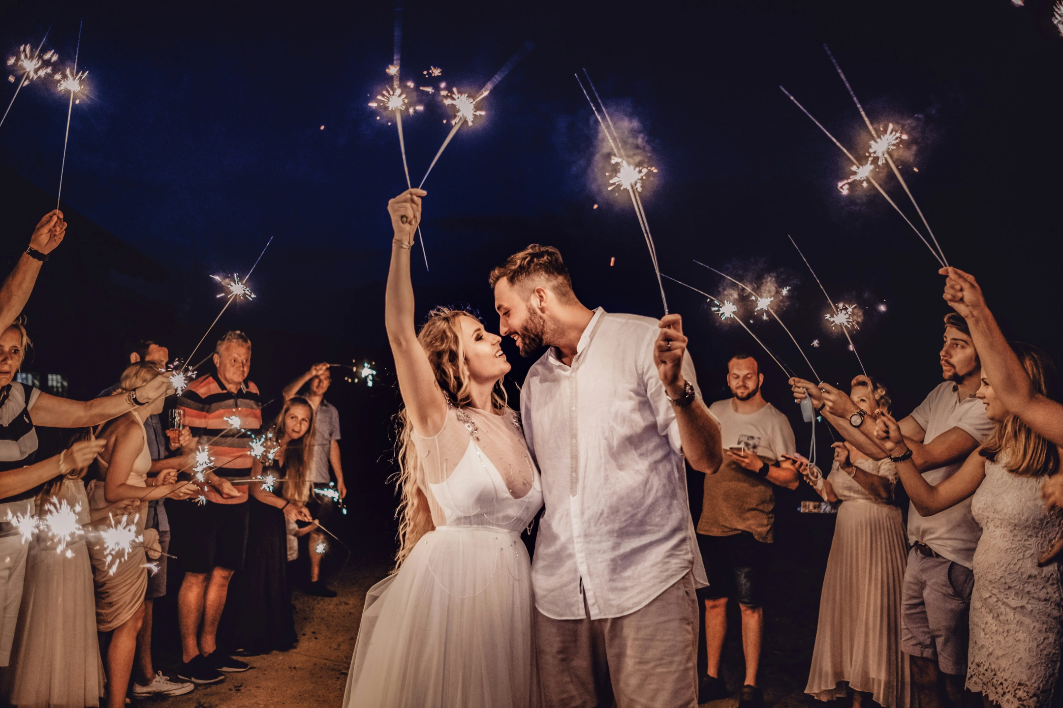 couple-in-love-wearing-white-holding-lit-sparklers.jpg