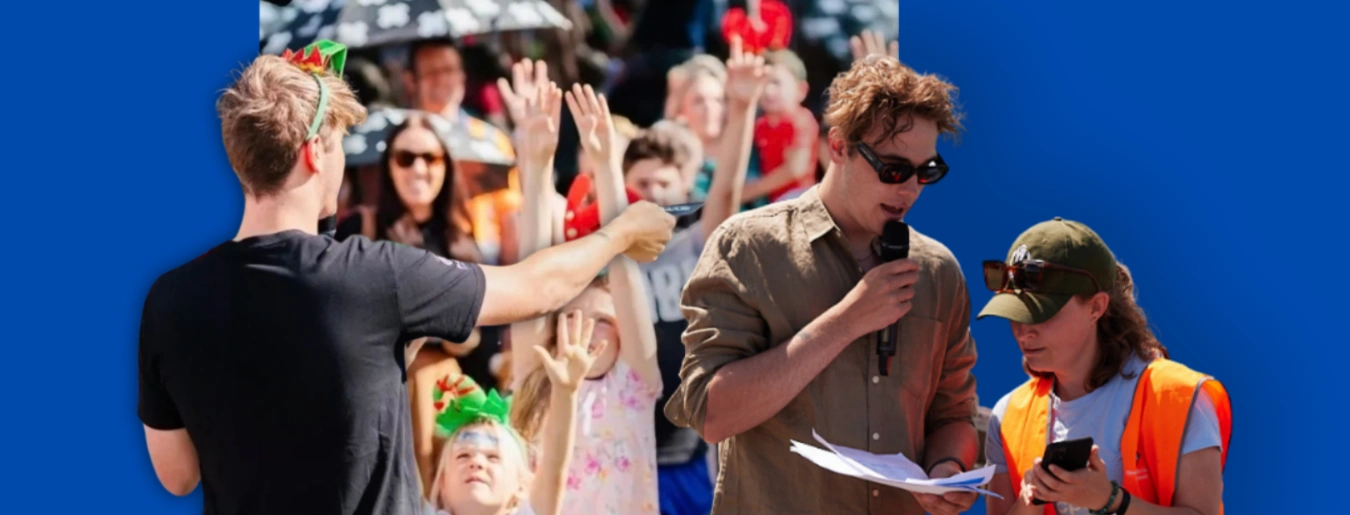 Hamish MCing an outdoor event with a microphone in front of a crowd