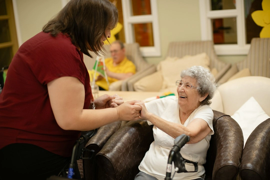 Carer helping older woman with walker at home