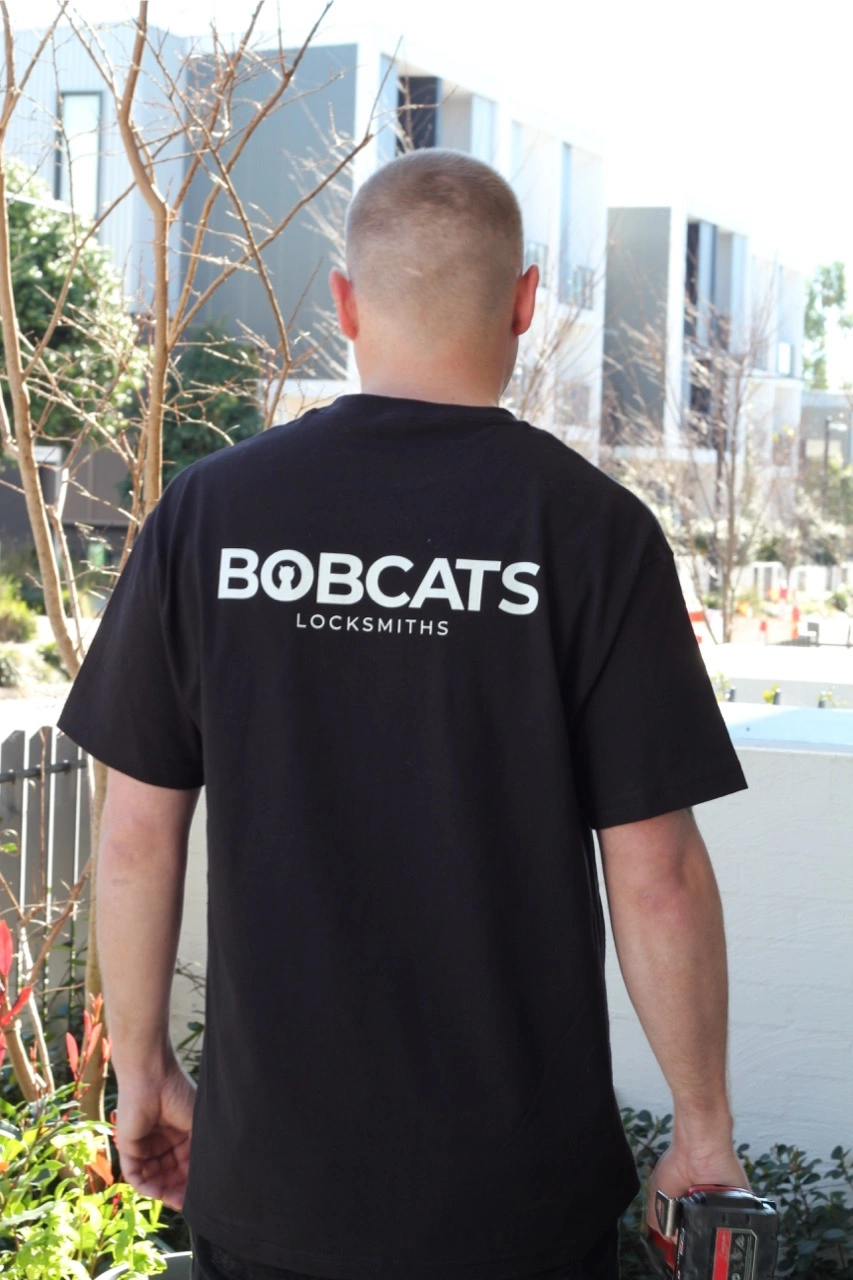 Stuart wearing bobcats locksmiths shirt back