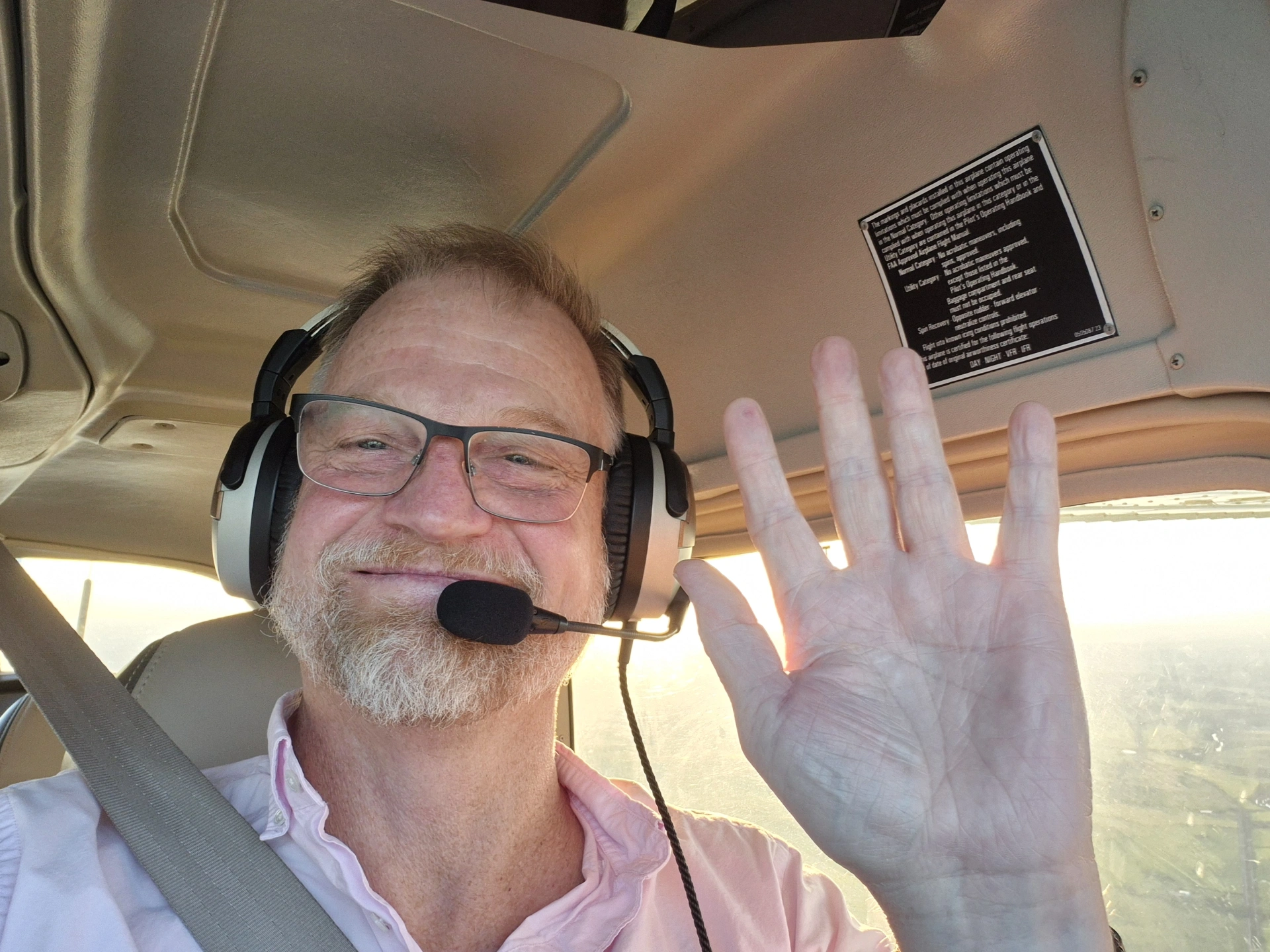 Steve waving from a plane cockpit