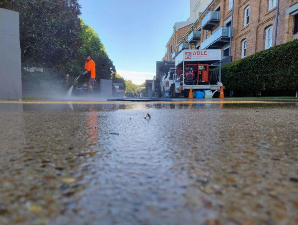 ABLE Employee cleaning concrete with trailer