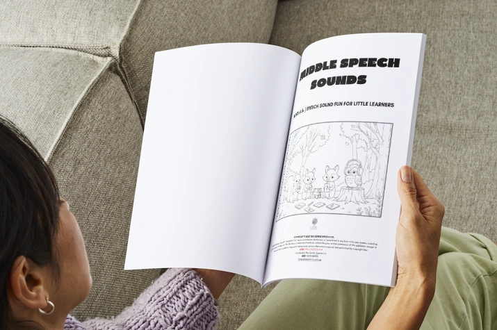 Workbook 2 held in hands on couch.png